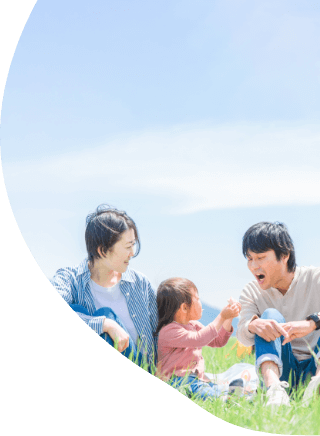 野原でサンドイッチを食べている親子
